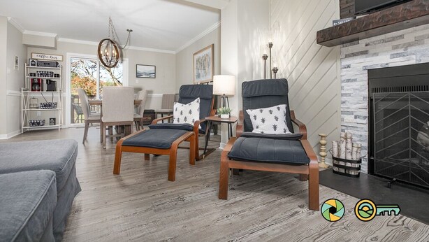 A modern living room with two leather armchairs, a coffee bar, and a fireplace.