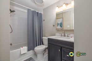 A bathroom with a bathtub, toilet, and vanity with a mirror. - Cozy Renovated Woodland Townhome | Minutes from Bryce Resort! (Basye)