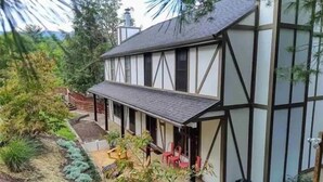 Ein zweistöckiges Haus mit überdachter Terrasse.