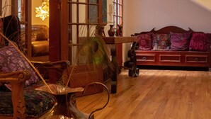 A spacious living room with a wooden floor, a staircase, and a view of the outdoors.
