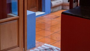 A narrow hallway with a wooden door and a blue wall.