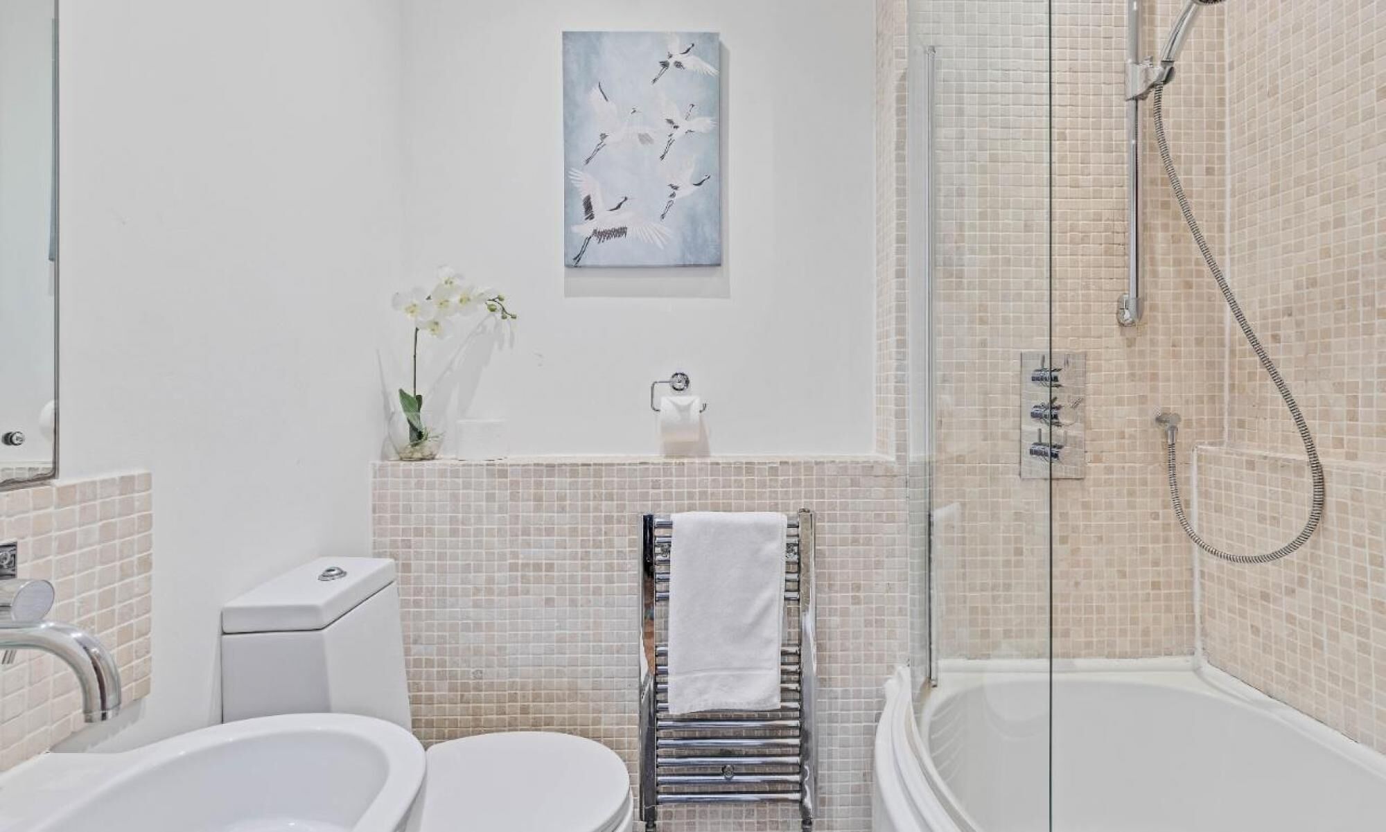 Een moderne badkamer met een bad, toilet en douche.