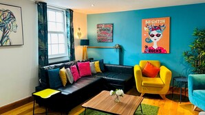 A modern living room with a black leather sofa, a yellow armchair, and a wooden coffee table. - Pebble Mews House - Sleeps 6 to 8 Guests (Brighton)