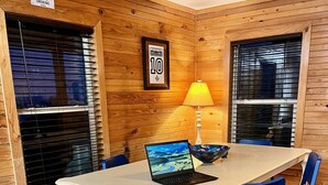 A dining area with a white table, blue chairs, a laptop, a bowl, and a lamp. - NEWLY RENOVATED Houseboat Located in Venice Marina (B Dock) (Venice)