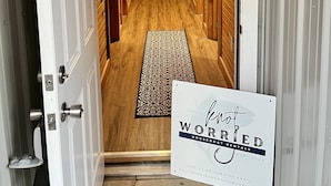 A hallway with wooden walls, a patterned rug, and a sign reading "Not Worried Houseboat Rentals." - NEWLY RENOVATED Houseboat Located in Venice Marina (B Dock) (Venice)