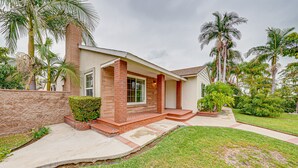A single-story house with a brick exterior, a front porch, and a well-maintained lawn. - Cozy, spacious 4B4B house with high-speed internet near Disney (West Covina)