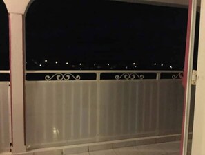 Un balcó amb barana metàl·lica i vista del cel nocturn.