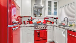 A kitchen with white cabinets, a red stove, and a red refrigerator. - Downtown Ruby Red Bungalow w/AC, Fully Fenced Yard, W/D, 2 Smart TVs, Fast WiFi (Flagstaff)