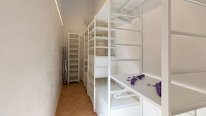 A narrow hallway with white shelving units and a wooden floor. - Cavour 83 Prestige House (Florence)