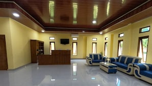 A spacious lobby with a reception desk, seating area, and large windows. - EduTel (Labuan Bajo)