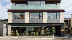A modern hotel with a glass facade, a cafe bar, and a sign indicating it is the Abita Hotel. - Abita Hotel Kyoto Kamogawa (Kyoto)