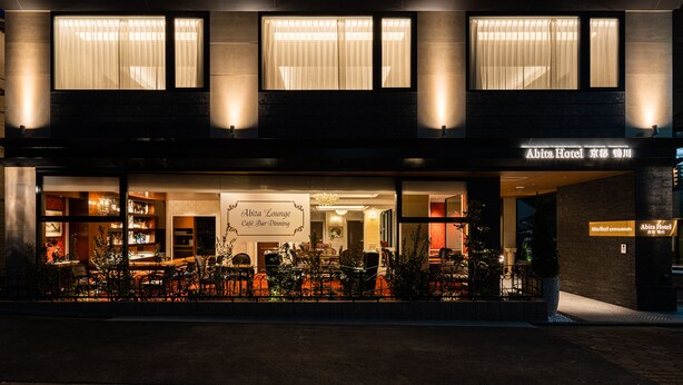 A hotel exterior with a café bar dining area, outdoor seating, and a sign indicating 'Abita Hotel Kyoto'. - Abita Hotel Kyoto Kamogawa (Kyoto)