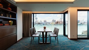 A hotel room with a large window, a dining table with chairs, a wooden cabinet, and a patterned carpet. - Abita Hotel Kyoto Kamogawa (Kyoto)