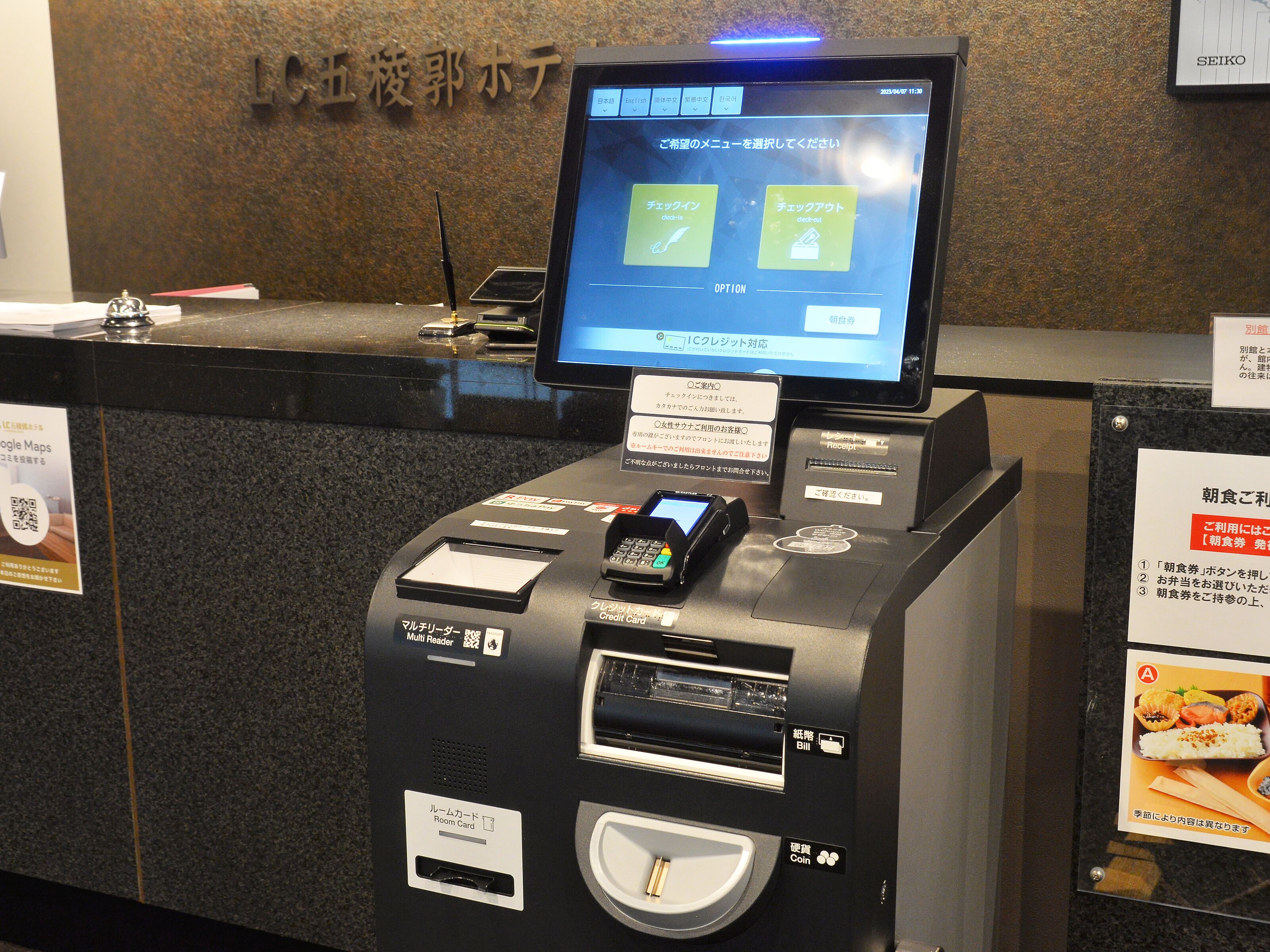 A self-service kiosk with a digital screen displaying options for check-in and check-out.