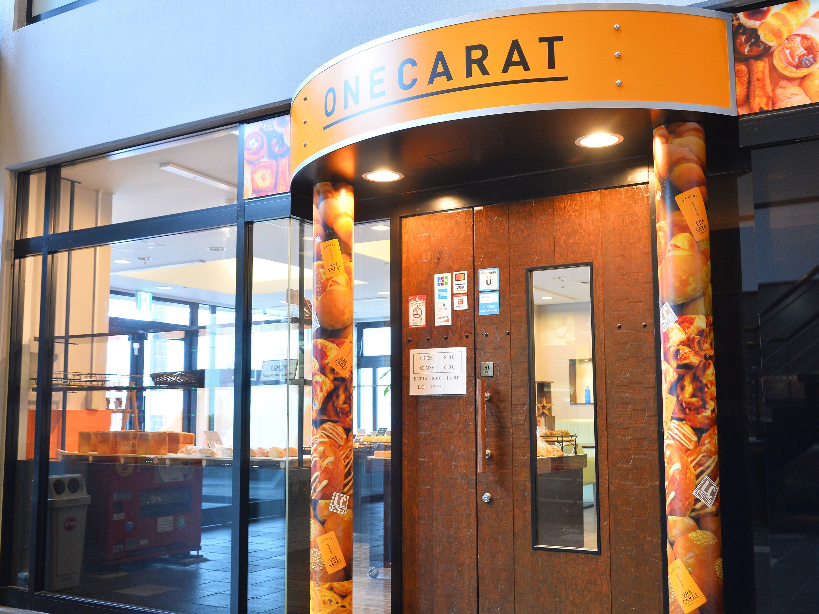 A bakery entrance with a sign reading "ONECARAT".