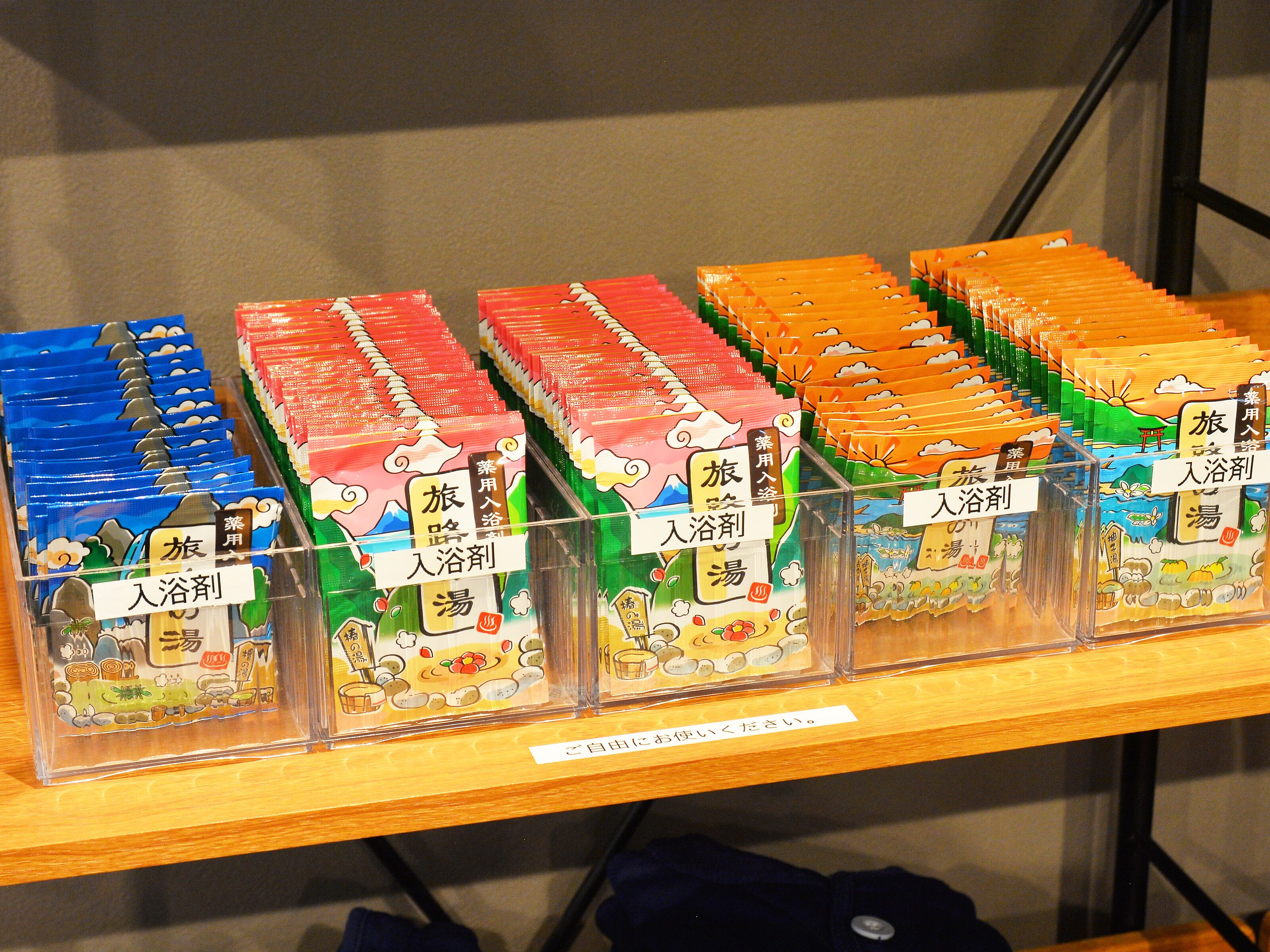 Una estantería con cajas ordenadas de productos de baño, cada una con texto en japonés.