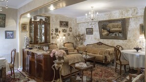 A vintage-style living room with a large mirror, ornate furniture, and a chandelier. - Elia Boutique Hostel & Apart-Hotel (Tbilisi)
