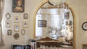 A room with a large mirror, a chandelier, and various framed pictures on the walls. - Elia Boutique Hostel & Apart-Hotel (Tbilisi)