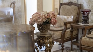 A room with a table, a chair, and a decorative vase with flowers. - Elia Boutique Hostel & Apart-Hotel (Tbilisi)