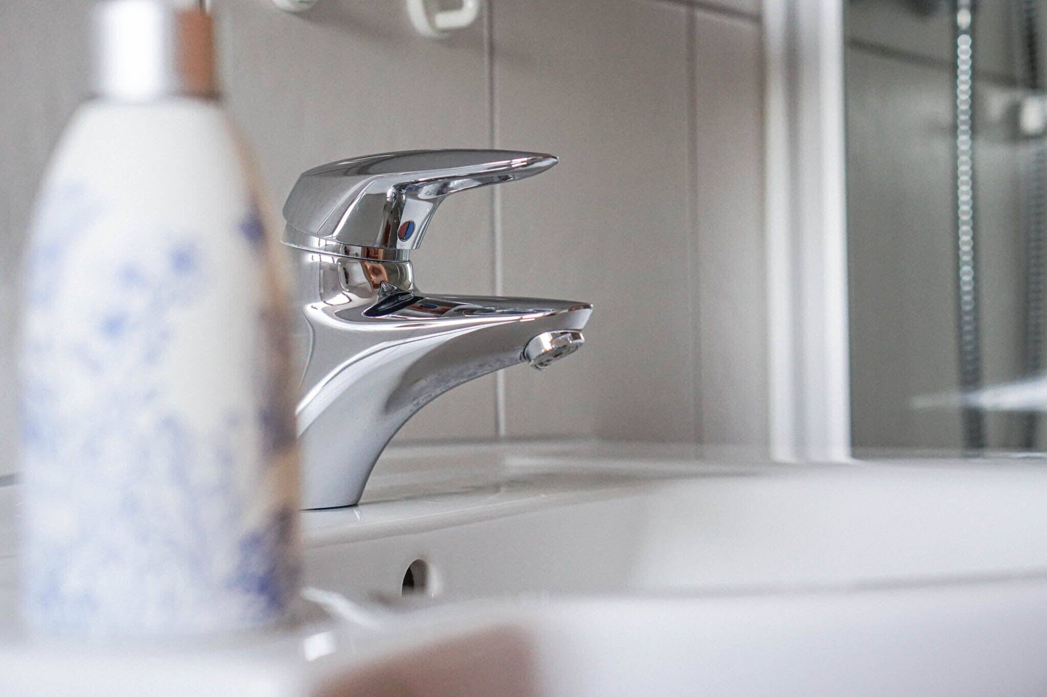 Ein modernes Badezimmer mit einem Chrom-Wasserhahn und einem weißen Waschbecken.