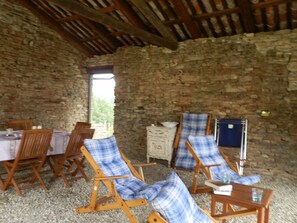 A rustic room with stone walls, wooden furniture, and a window providing natural light. - Ca der Forn the Bread Oven House in Cascina Bricchetto Langhe - Italy (Trezzo Tinella)
