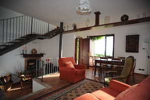 Un salon spacieux avec un escalier, une cheminée et un coin repas.