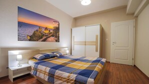A bedroom with a bed, bedside table, and a wardrobe.