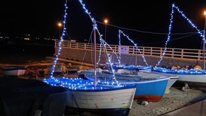Several boats decorated with blue lights, docked at a pier with a railing and a street lamp. - Locanda Badia Residenze Iride e Celeste (Castellabate)