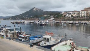 A marina with boats docked along the waterfront, a hill in the background, and buildings on the right. - Locanda Badia Residenze Iride e Celeste (Castellabate)