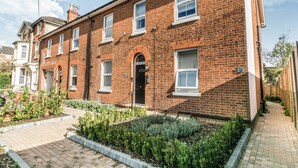 A red brick residential building with a front garden, a paved walkway, and a clear sky. - 14 Helena House Lux Apartment (Reading)