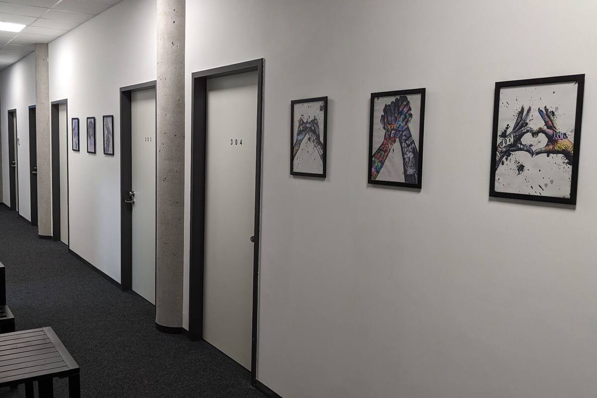 A hallway with doors numbered 304 and 305, and three framed artworks on the wall.