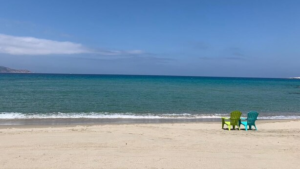A beach with two green chairs and a table facing the ocean. - RESIDENCE U MANELLU (Santa-Reparata-di-Balagna)