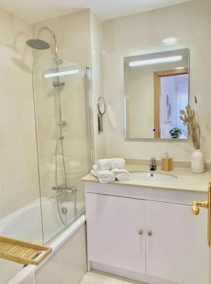Een bad/douchecombinatie, een haardroger, een bidet, handdoeken