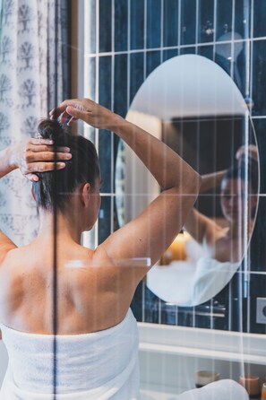 Panorama tweepersoonskamer | Badkamer | Een douche, een regendouche, een haardroger, handdoeken