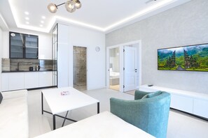 Leilighet – deluxe | Oppholdsområde | En 1-tommers Flatskjerm-TV med kabel-kanaler samt TV