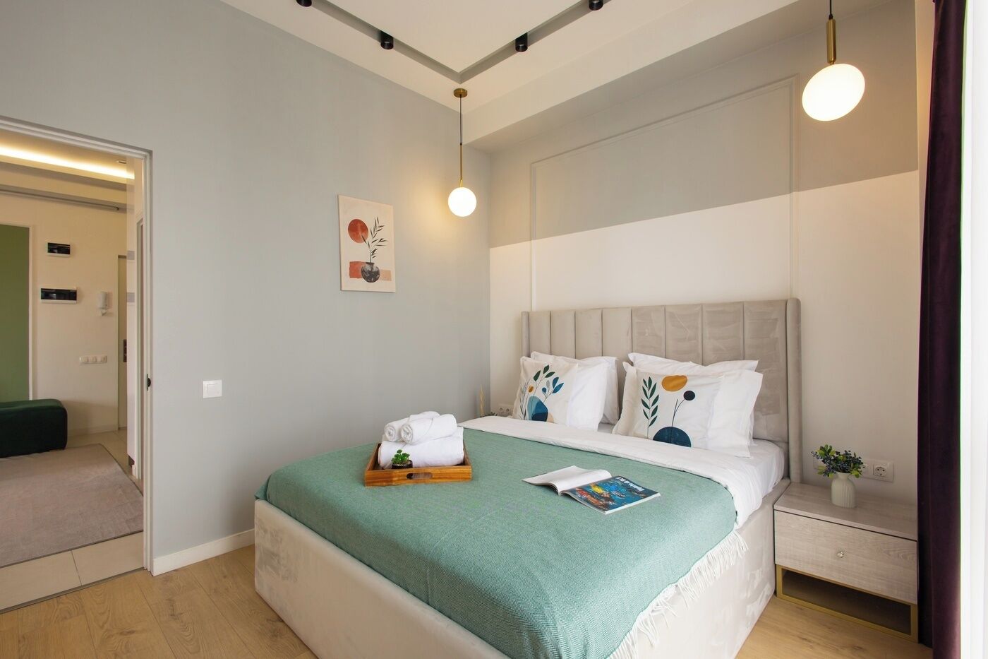 Et moderne hotelværelse med seng, natbord og en lille urtepotte.