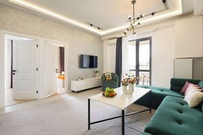 Appartamento Deluxe | Area soggiorno | TV a schermo piatto 1 pollici con canali via cavo, TV