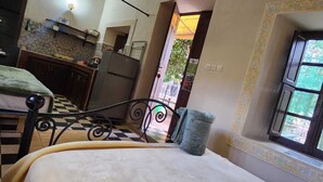 Ein Schlafzimmer mit Bett, einem Fenster mit Aussicht, einer Küchenzeile und einem Badezimmer.