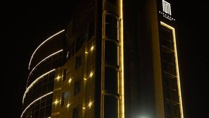 A hotel with a modern design, featuring a curved facade and illuminated windows. - Central Park Resident (Bishkek)