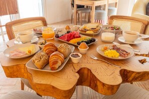 A breakfast table with croissants, fruits, eggs, and coffee. - Deluxe Double Room with Balcony (Veiros)