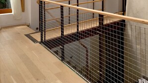 A high-ceilinged room with a skylight, a wooden railing, and a view of greenery outside. - Architect's house - 10000m2 garden and undergrowth (Bains-sur-Oust)