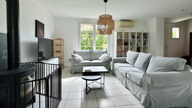 A modern living room with a fireplace, a sofa set, a coffee table, and a bookshelf. - La Mandragora - Atelier d’art et poésie (Vernon)