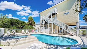 A swimming pool area with lounge chairs and a staircase leading to a building. - Paradise Falls here! 4 BR, Elevator, Pool, across the street from beach (ST GEORGE ISLAND)
