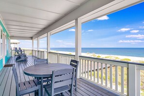 A covered deck with a table and chairs, overlooking a beach. - DESTINATION RELAXATION 4 BR 4 BATH BEACHFRONT home with PRIVATE POOL (St. George Island)
