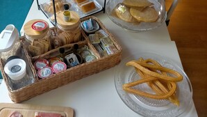 A buffet table with various food items including meats, cheeses, breads, and fruits.