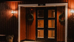Un bâtiment en bois avec une enseigne portant l’inscription « Kapell » au-dessus de l’entrée.