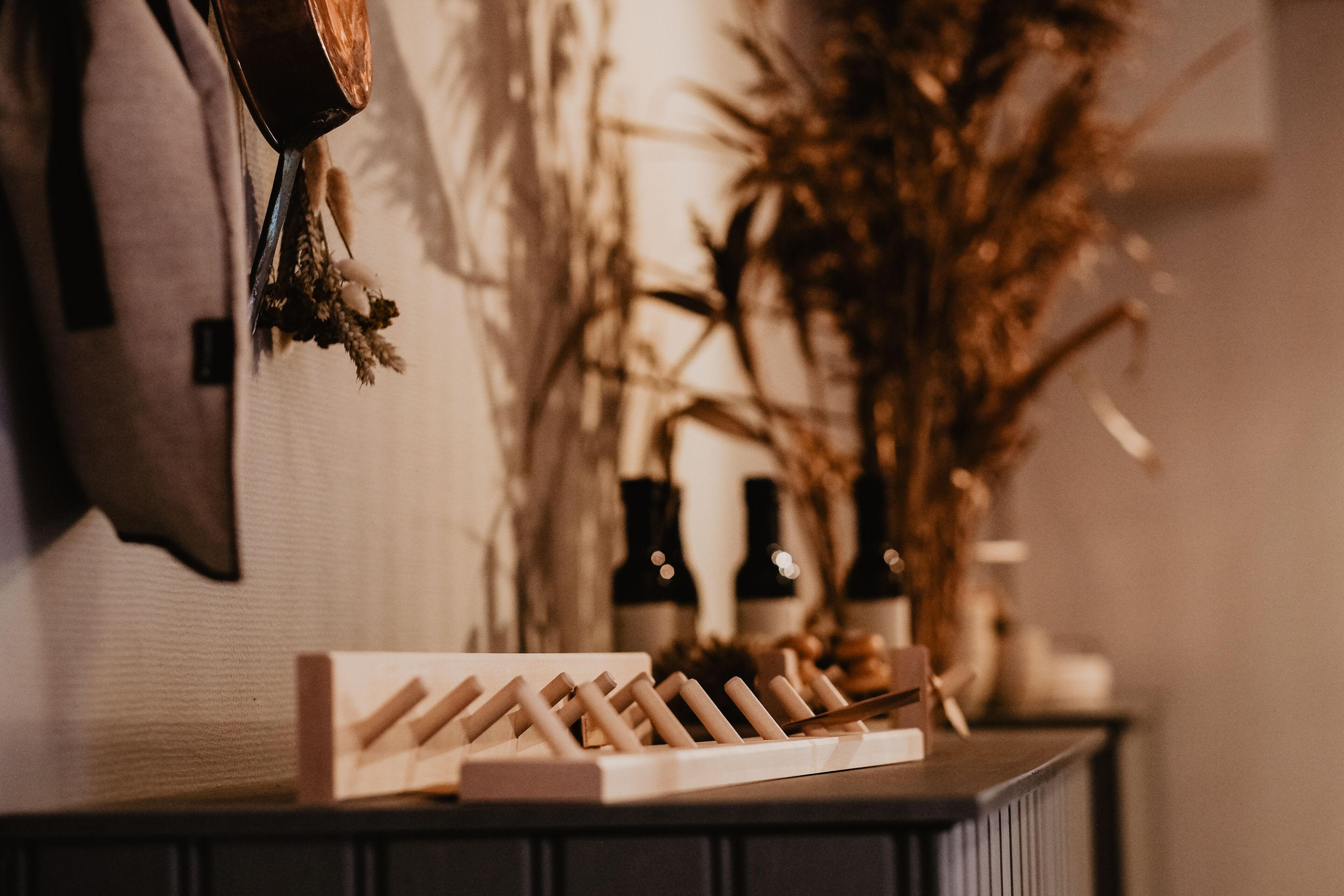 Un meuble à bouteilles contenant des bouteilles de vin et un objet décoratif, le tout posé sur une surface sombre.