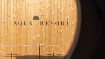 Un muro di legno con la scritta "AQUA RESORT" e una parte di una recinzione.