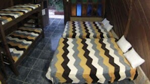 Une pièce confortable à la voûte impressionnante, avec un lit et deux bancs.