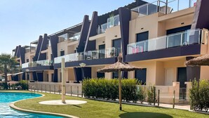 Un hotel moderno con piscina, zona de estar al aire libre y césped bien cuidado.
